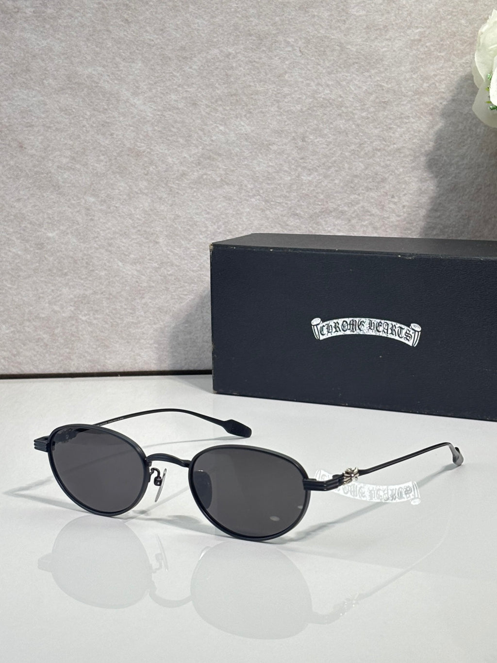 Round black sunglasses with dark lenses and slim chrome arms