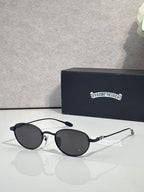 Round black sunglasses with dark lenses and slim chrome arms