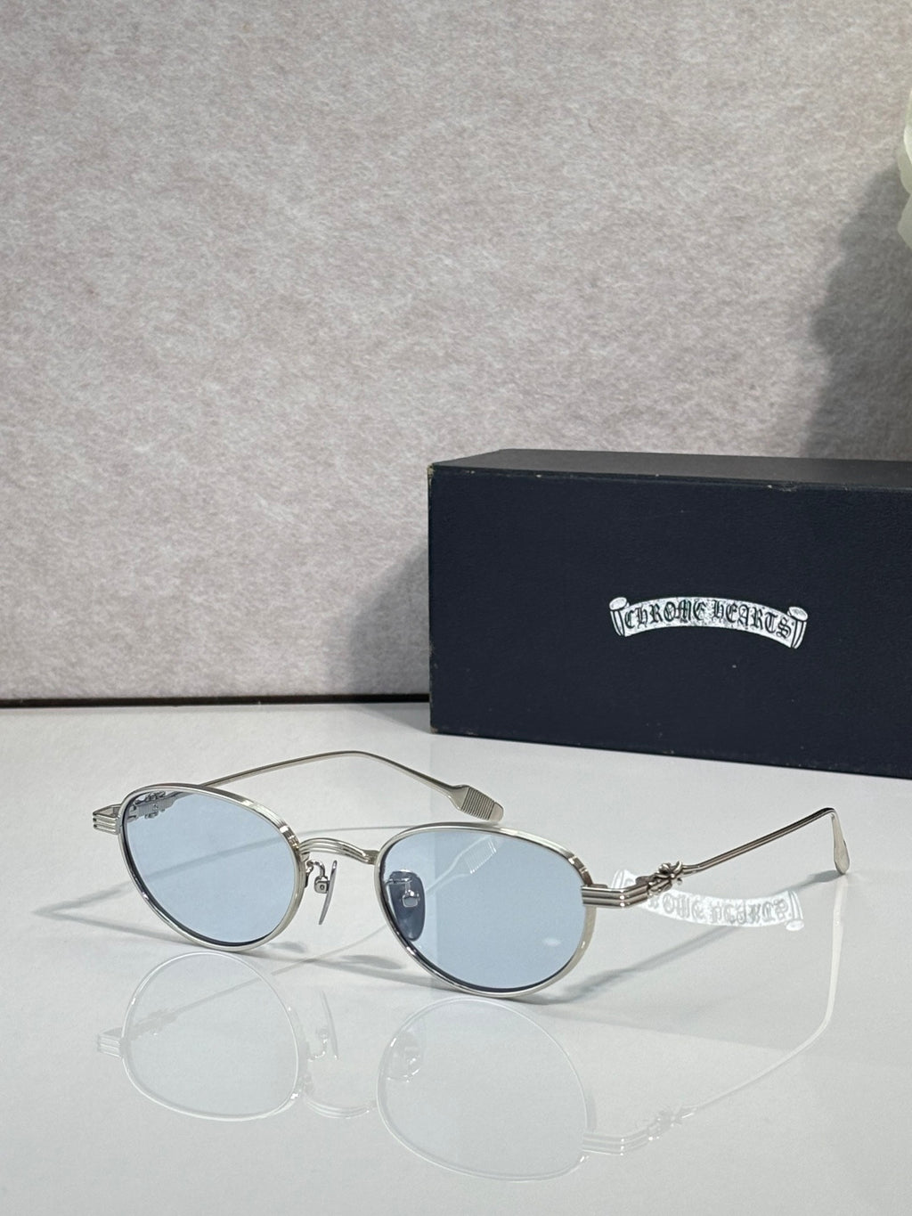 Round clear sunglasses with light blue lenses and silver-toned frame