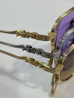 Close-up of gold and chrome sunglasses temples with ornate end details
