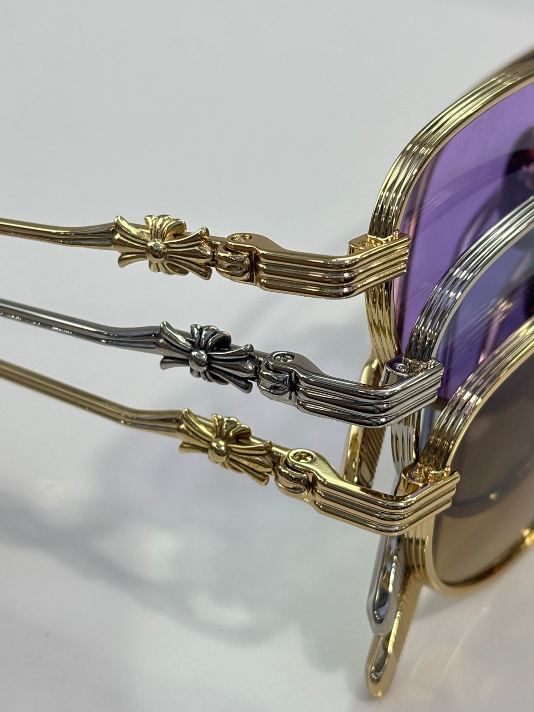 Close-up of gold and chrome sunglasses temples with ornate end details