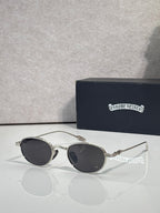 Round sunglasses with dark lenses and silver-toned frame with decorative temples