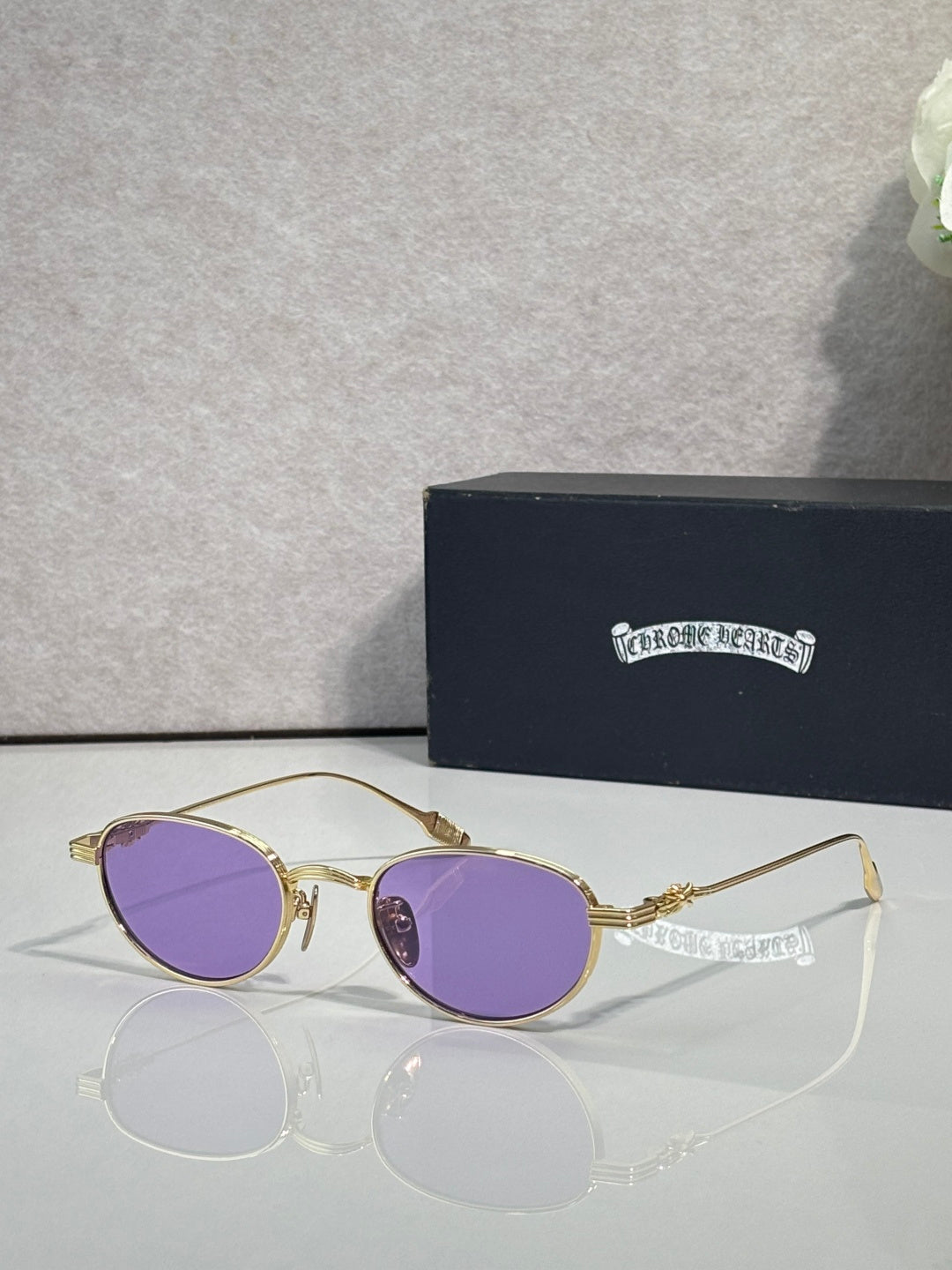 Round gold sunglasses with purple lenses and ornate temple hardware