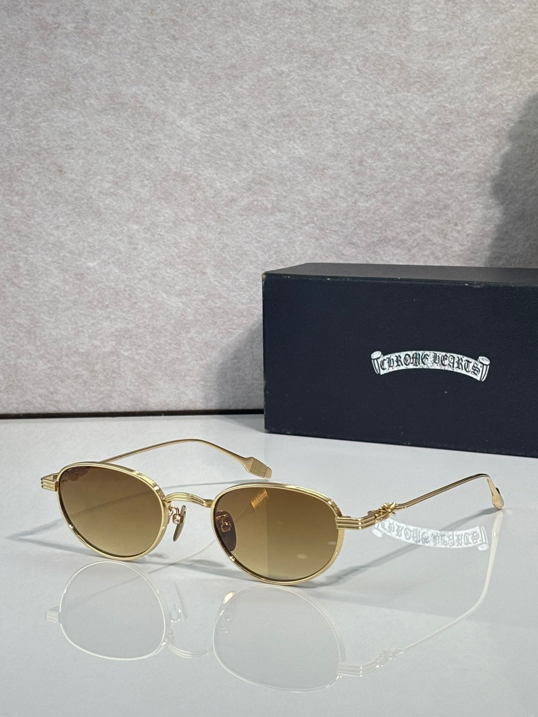 Round gold sunglasses with amber lenses and clear temple accents