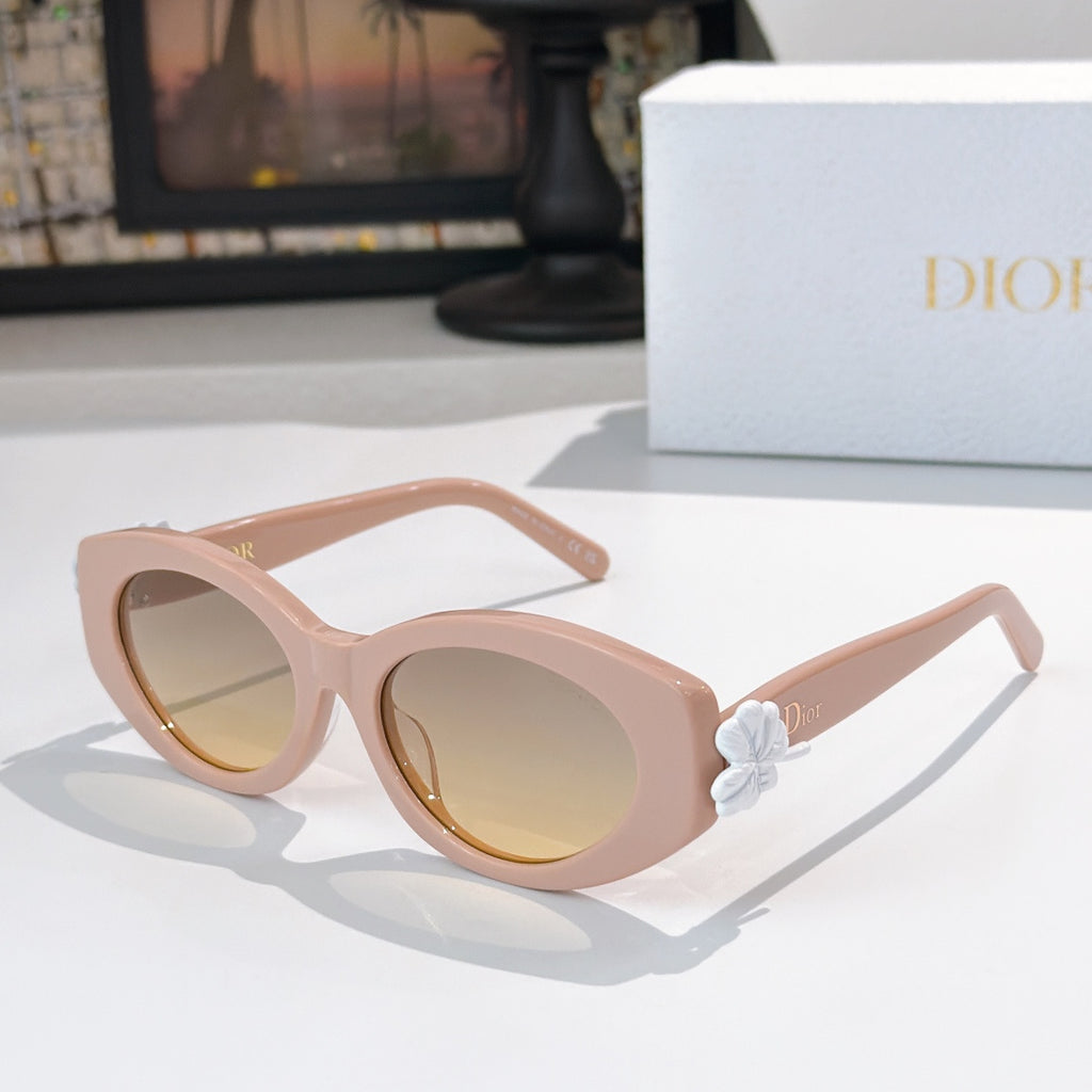 Dior sunglasses with pale pink frames and tinted lenses, featuring a white flower detail.