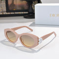 Dior sunglasses with pale pink frames and tinted lenses, featuring a white flower detail.