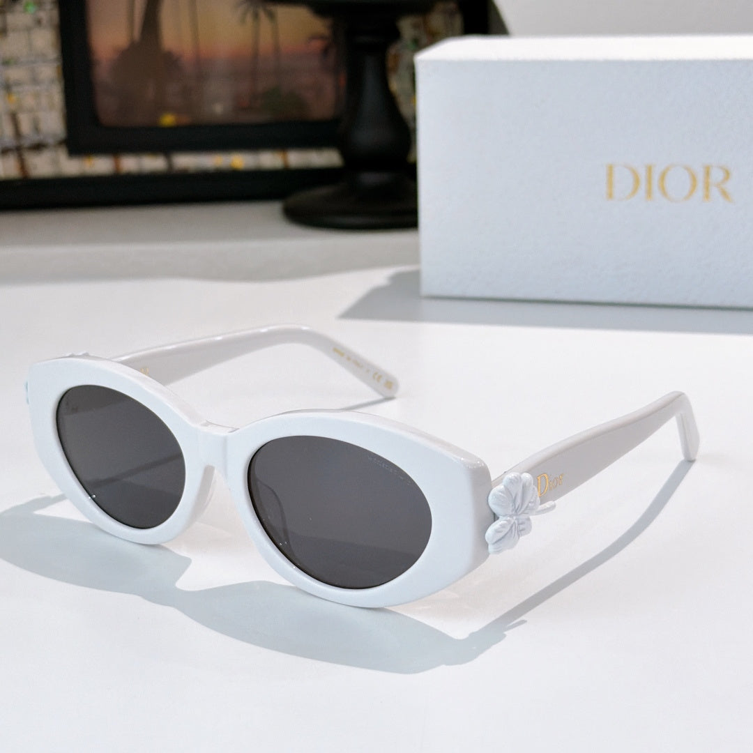 Dior sunglasses with white frames and dark tinted lenses, featuring a white flower detail.
