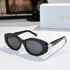 Dior sunglasses with black frames and dark lenses, with a white flower detail on the temple.