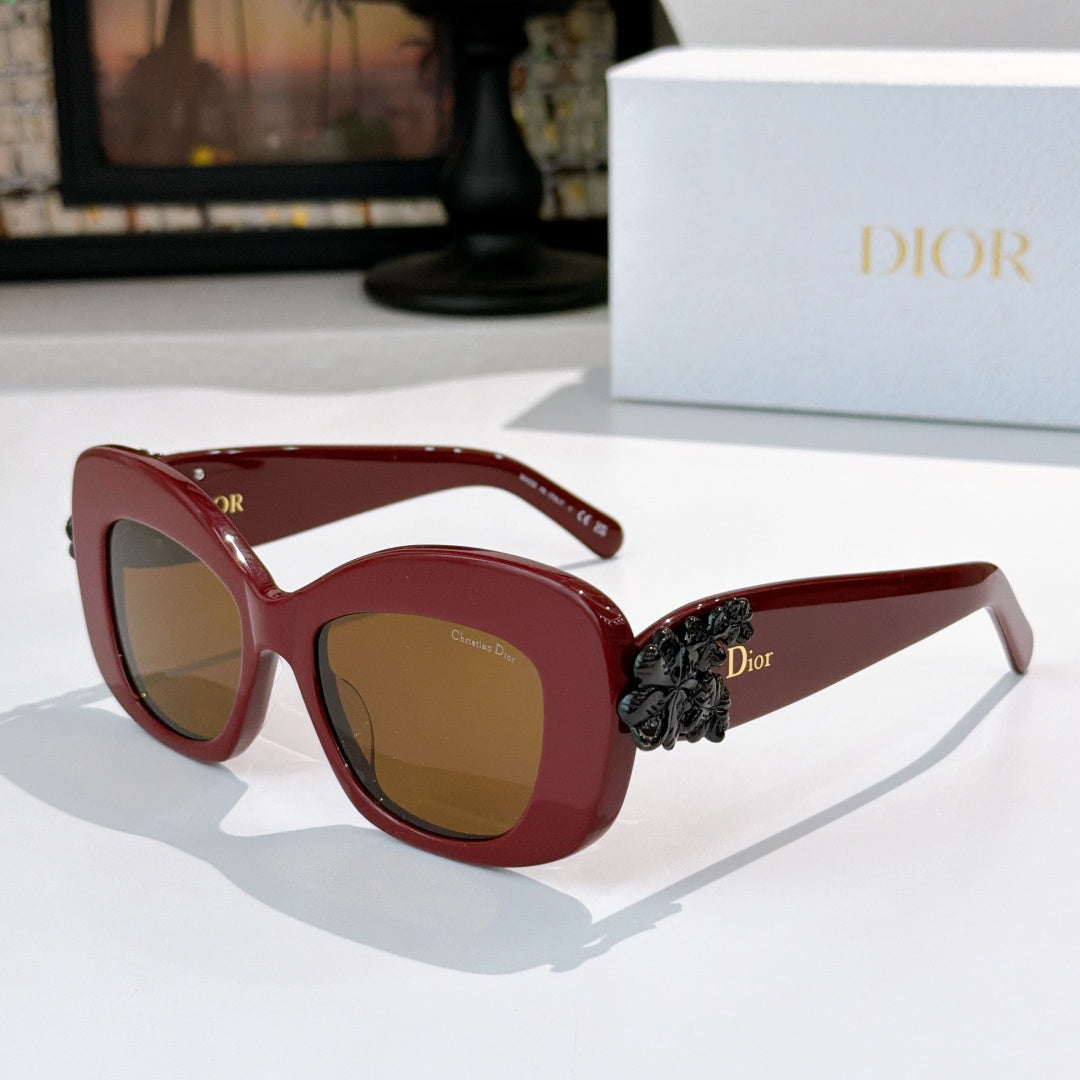 Dior sunglasses with burgundy frames, brown lenses, and dark floral temple detail