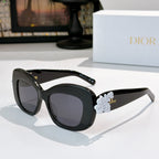Dior sunglasses with black frames and pale blue floral temple detail with dark lenses