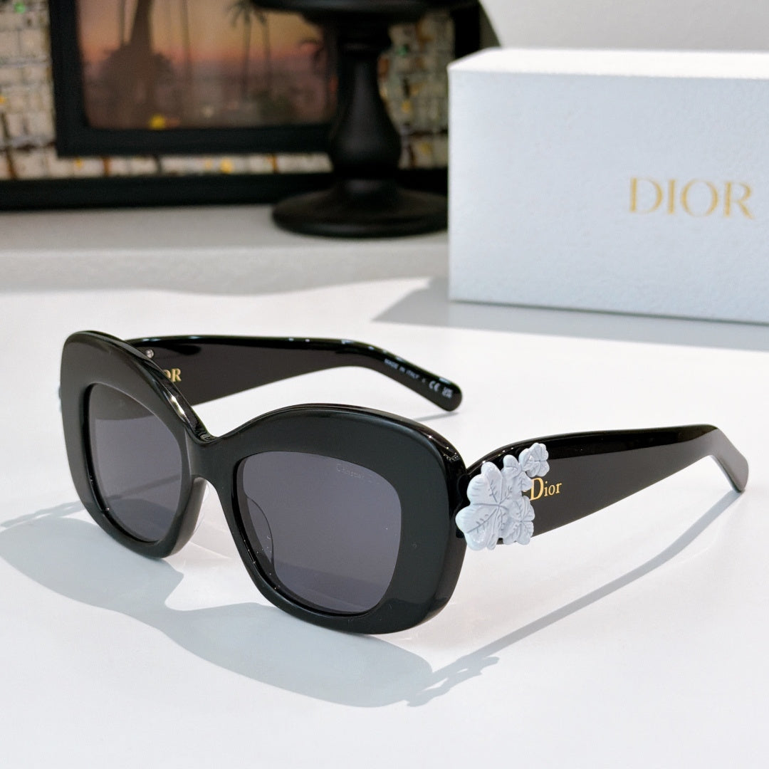 Dior sunglasses with black frames and pale blue floral temple detail with dark lenses