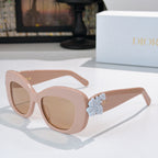 Dior sunglasses with light pink cat-eye frames and pale blue floral temple detail