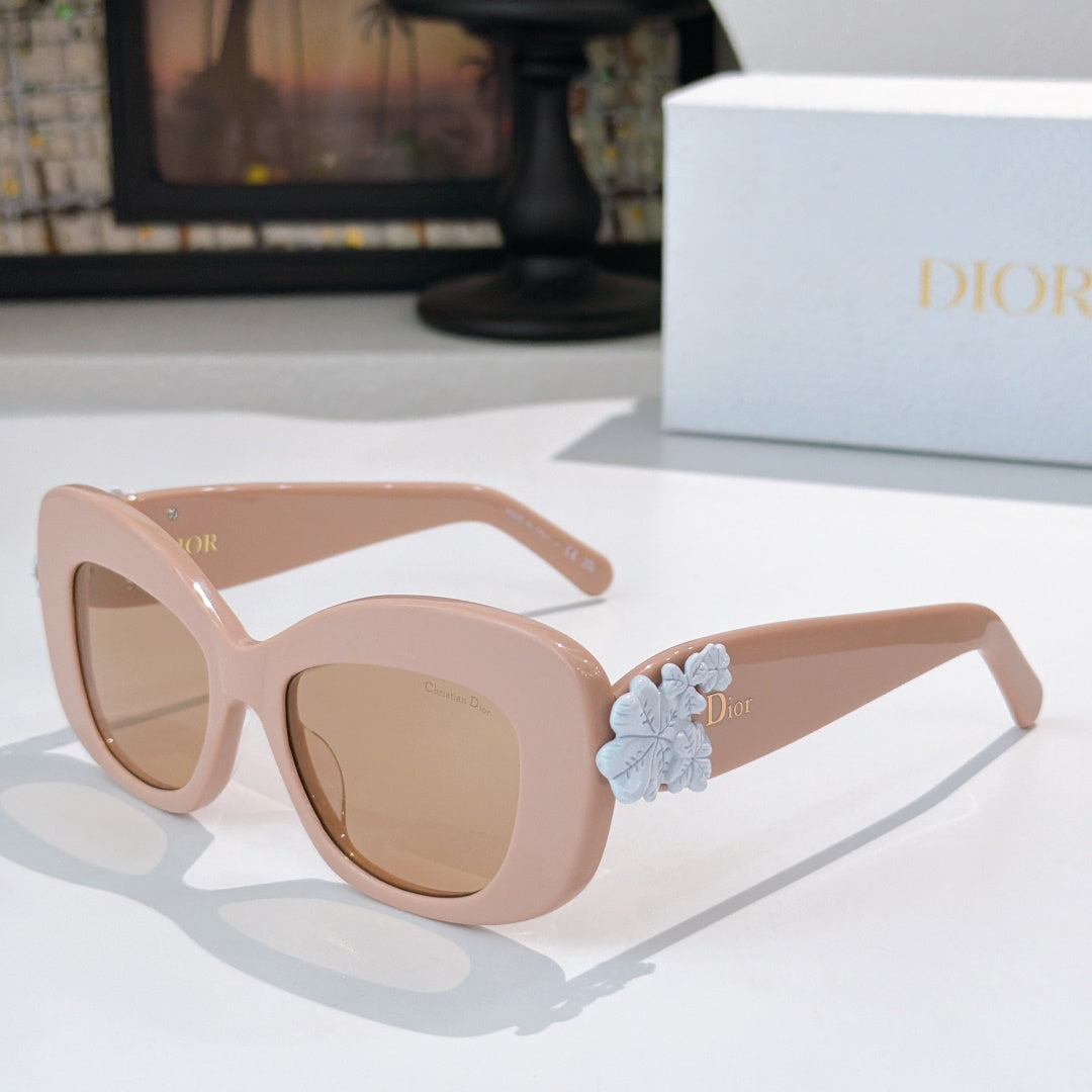 Dior sunglasses with light pink cat-eye frames and pale blue floral temple detail