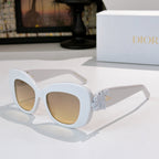 Dior sunglasses with white cat-eye frames and pale blue floral temple detail