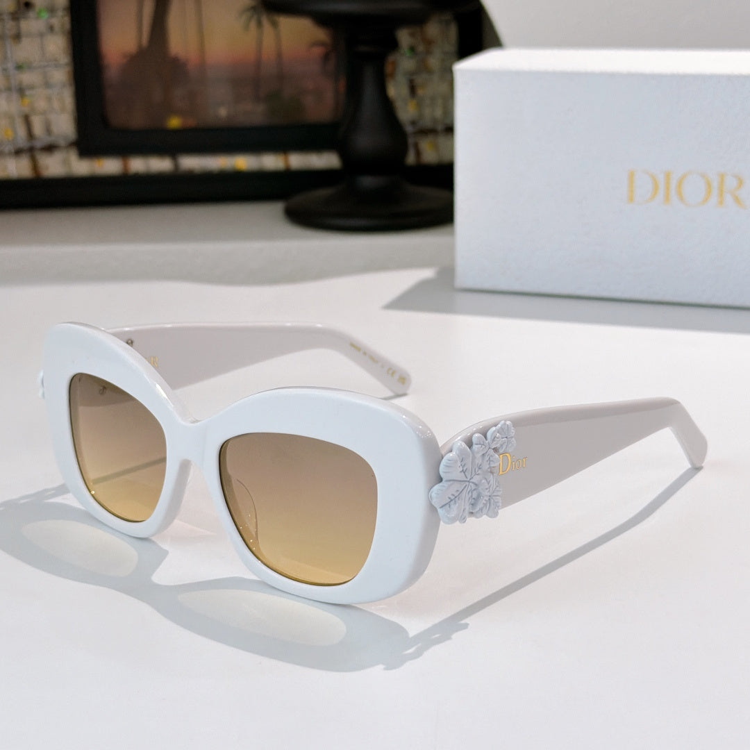 Dior sunglasses with white cat-eye frames and pale blue floral temple detail