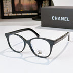 Black eyeglasses with round lenses and gold chain-style detail on the temple
