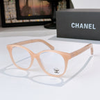 Light peach eyeglasses with round lenses and gold logo detail on the temple