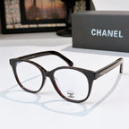 Black and brown gradient eyeglasses with round lenses and gold logo detail