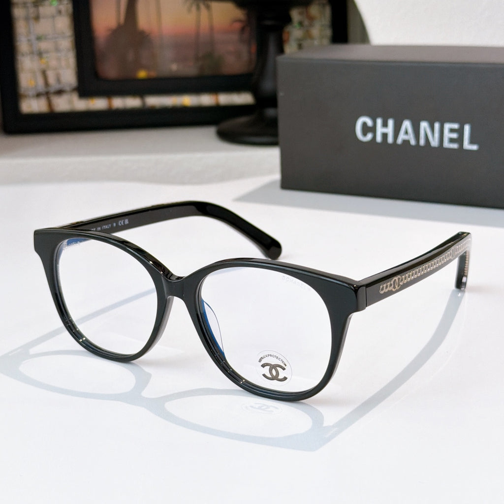 Black eyeglasses with round lenses and gold chain-style temple detail