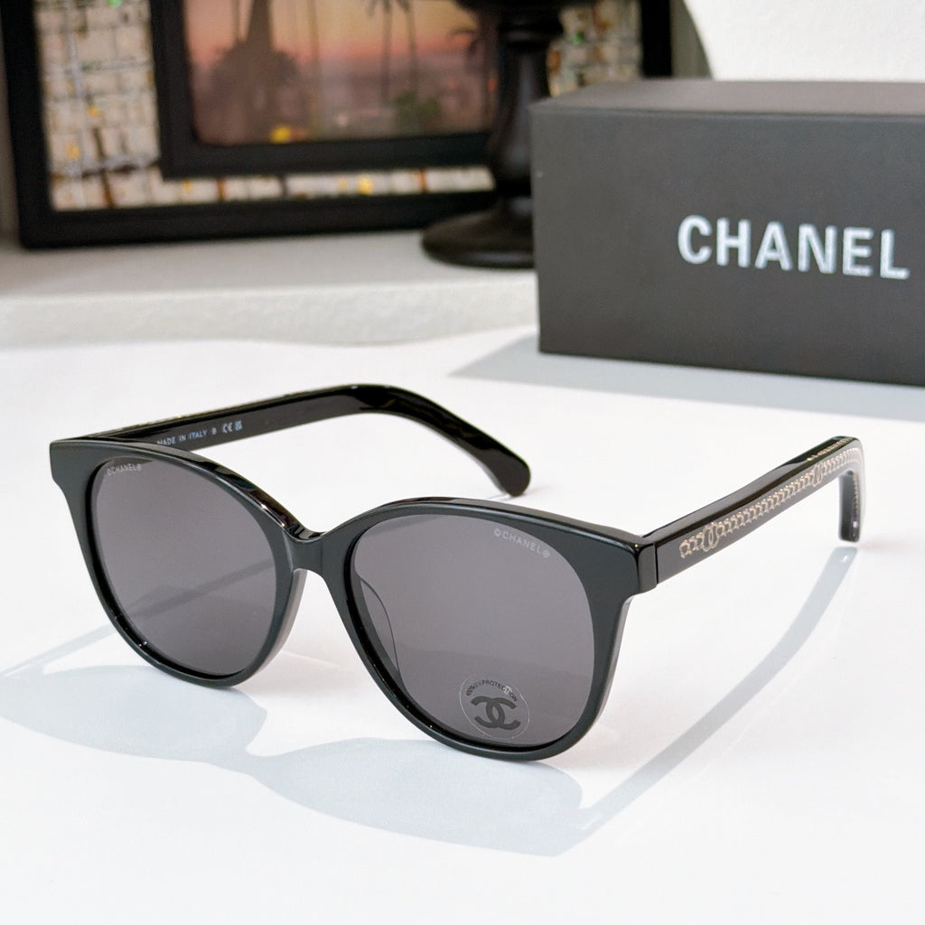Chanel sunglasses with black frames and dark gray lenses, round cat-eye shape