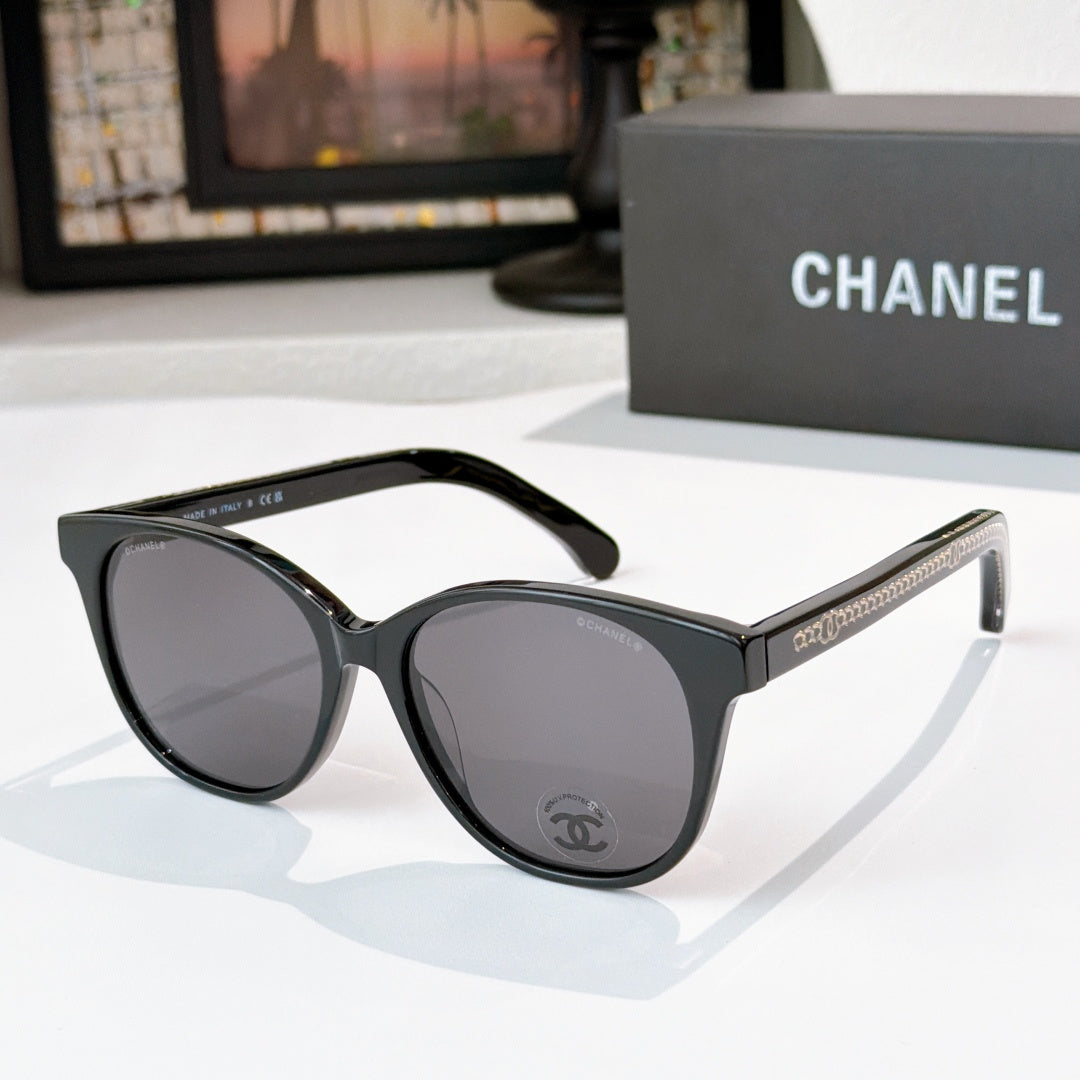 Chanel sunglasses with black frames and dark gray lenses, round cat-eye shape