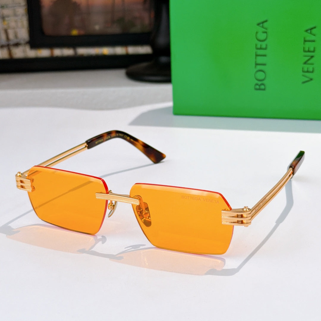 Bottega Veneta glasses with orange tinted lenses, gold frame, tortoise temple arms.