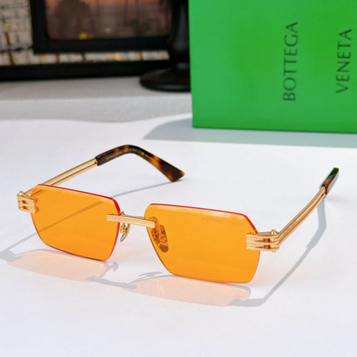 Bottega Veneta glasses with orange tinted lenses, gold frame, tortoise temple arms.