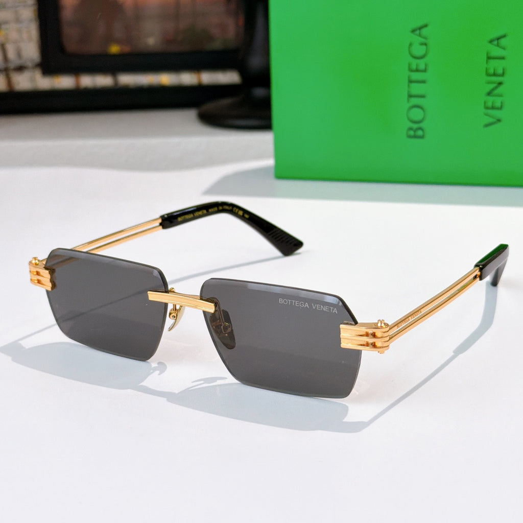 Bottega Veneta glasses with dark gray lenses, gold temples, black top frame accents.