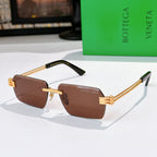 Bottega Veneta glasses with brown lenses, gold temples, black top frame accents.