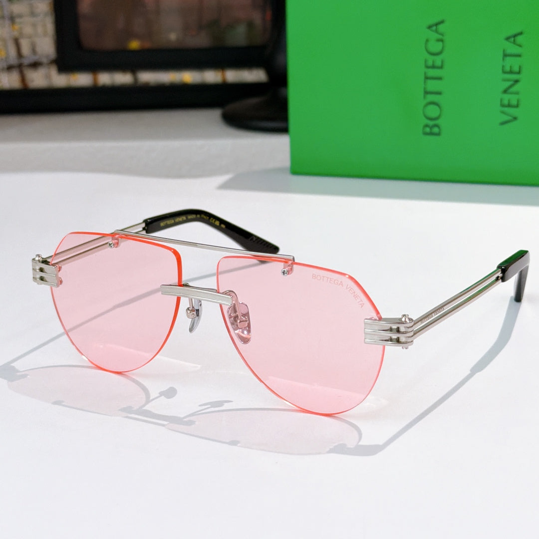 Sunglasses with pink lenses, pink frame, and orange-tinted accents on temples