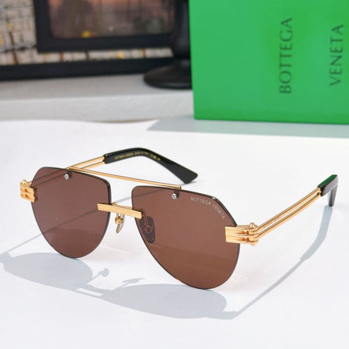 Sunglasses with dark brown lenses, gold frame, and tortoise-accent temples