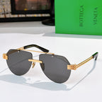 Sunglasses with dark lenses, gold frame, and tortoise-accent temples