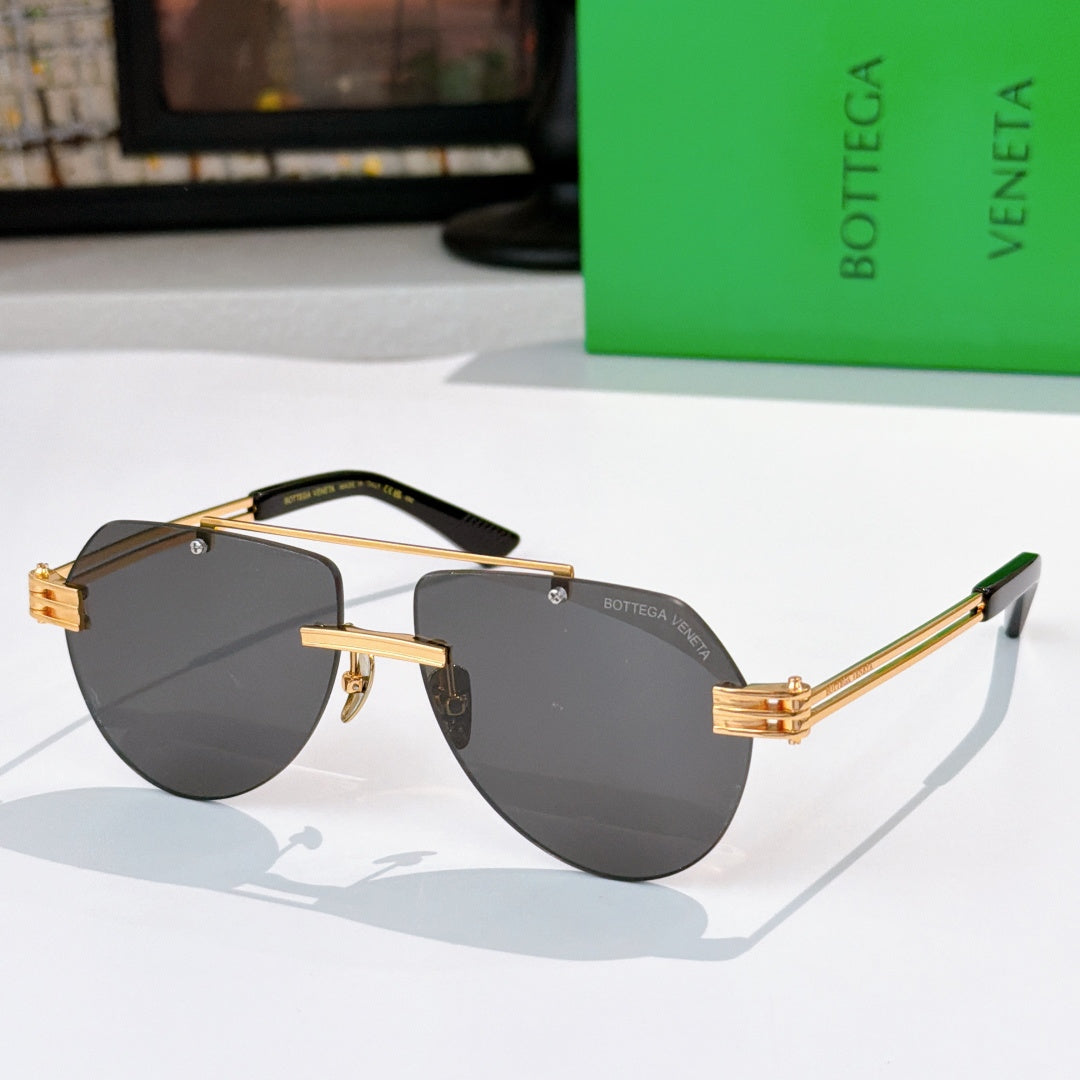 Sunglasses with dark lenses, gold frame, and tortoise-accent temples