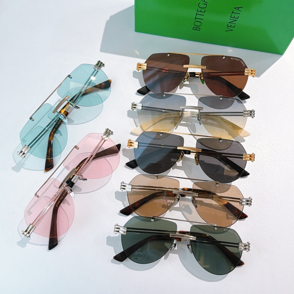Assorted sunglasses laid out: blue, brown, pink, and green tinted lenses
