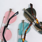 Sunglasses with pink, black, and teal lenses shown from above