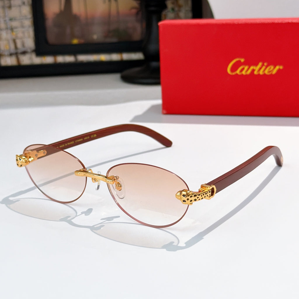 Gold-tone round sunglasses with light brown lenses and ornate temple detail
