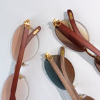 Gold-tone sunglasses with wood-look temples and ornate hinge hardware