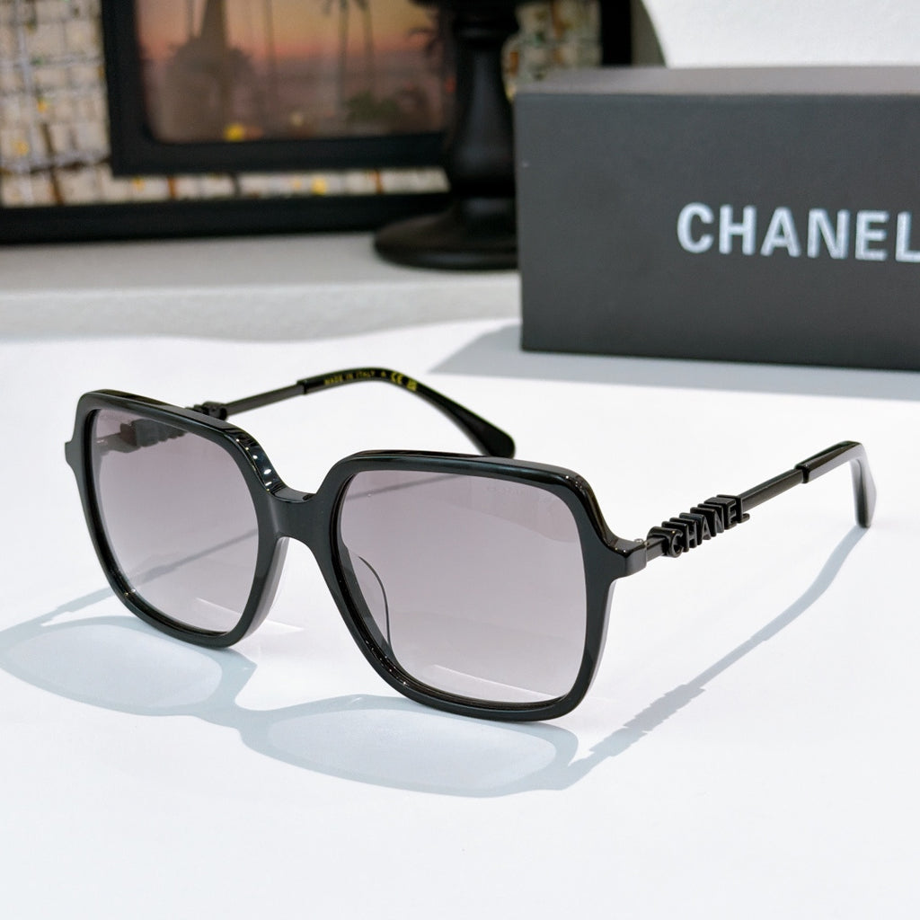 Black sunglasses with light gray lenses and textured logo temple hardware