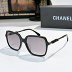 Black sunglasses with light gray lenses and textured logo temple hardware
