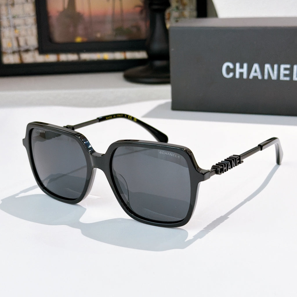 Black sunglasses with gray lenses and textured logo temple hardware