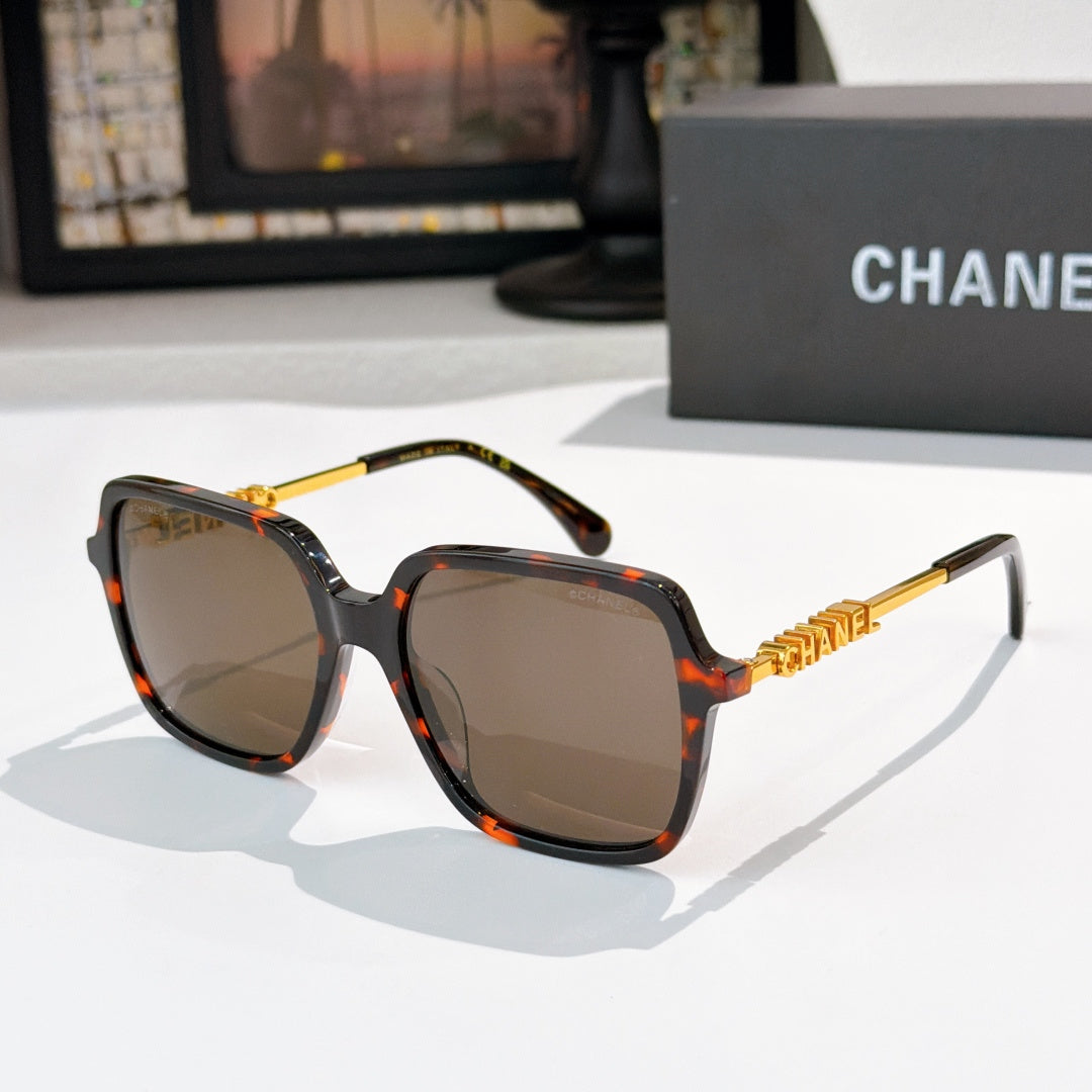 Tortoiseshell sunglasses with dark lenses and gold logo temples