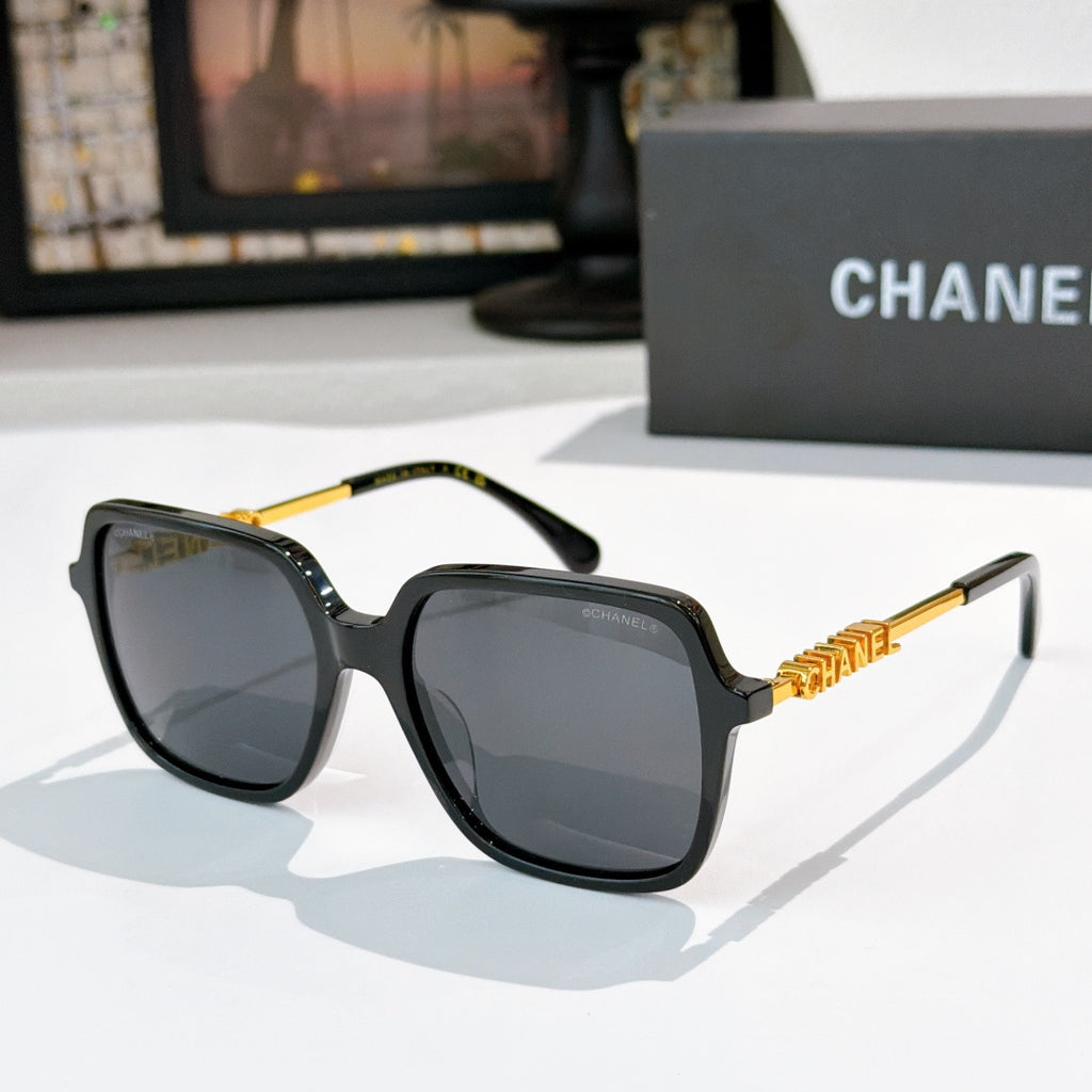 Dark tortoiseshell sunglasses with gray lenses and gold logo detail temples