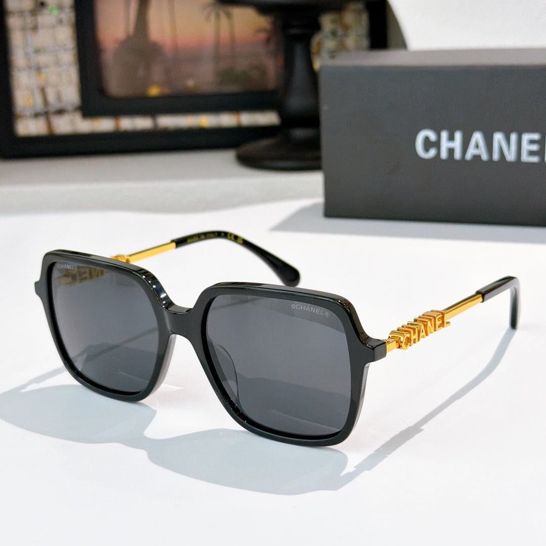 Dark tortoiseshell sunglasses with gray lenses and gold logo detail temples