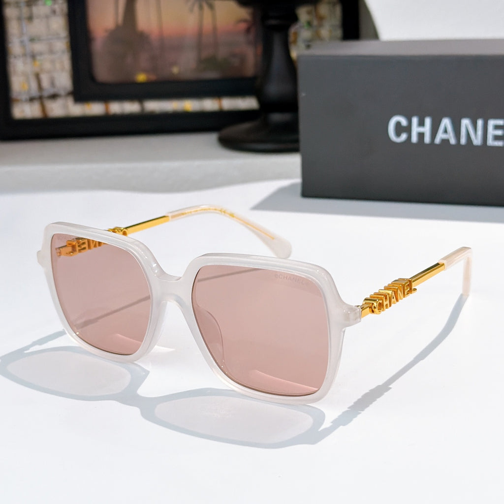 Clear white sunglasses with pink-tinted lenses and gold logo temples