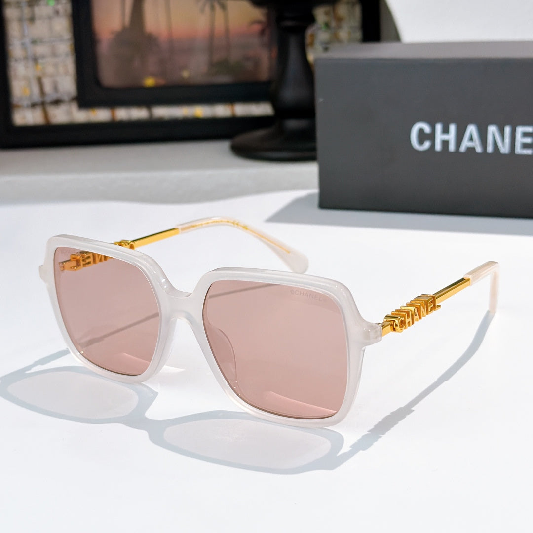 Clear white sunglasses with pink-tinted lenses and gold logo temples