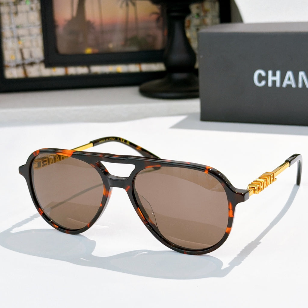 Sunglasses with tortoiseshell frame, brown tinted lenses, and gold-tone temple details