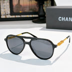 Sunglasses with black frame, dark blue tinted lenses, and gold-tone temple details