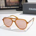 Sunglasses with amber orange frame, pink tinted lenses, and gold-tone temple details