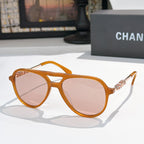 Sunglasses with amber orange frame, pink tinted lenses, and gold-tone temple details