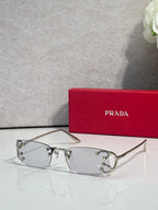 Eyeglasses by Prada with silver frame and clear lenses, studded detail at temples